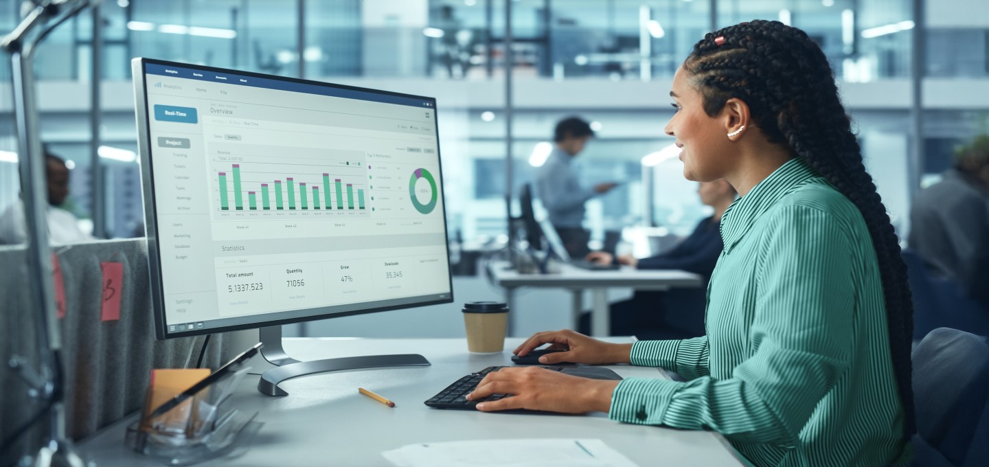 Woman with long dark braids in green shirt in office looking at financial