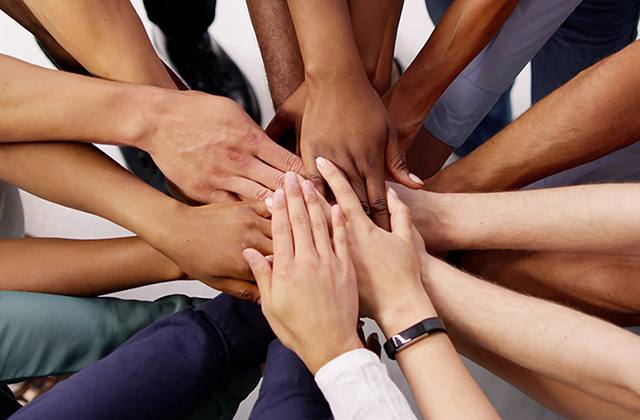 Eine Gruppe von Menschen legt ihre Hände zusammen